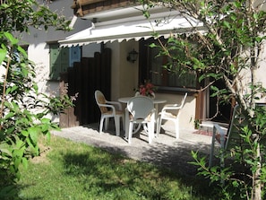 A patio with a table and chairs, a wooden fence, and a building with a white exterior. - Am Bildweg (Stahel) Appartement/Fewo, Dusche oder Bad, WC 2½-Zimmerwohnung by Interhome (Klosters)