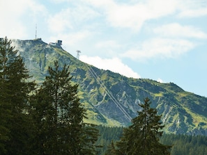 Eine Berglandschaft mit einem Strommasten und einem Gebäude auf dem Gipfel.