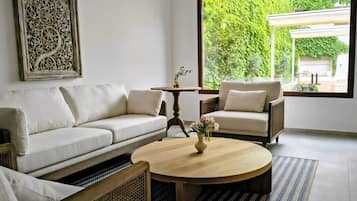 Suite superior, baño privado, en edificio anexo | Zona de estar