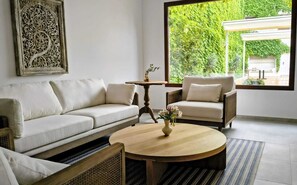Suite superior, baño privado, en edificio contiguo | Área de sala de estar