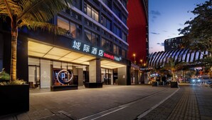 A modern hotel with a prominent entrance, large windows, and a well-lit facade. - Intercity Hotel Guangzhou Chimelong Wanbo Sihai City (Guangzhou)