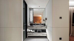 A modern bathroom with a marble vanity, a large mirror, and a wooden door in the background. - Intercity Hotel Guangzhou Chimelong Wanbo Sihai City (Guangzhou)