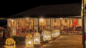 A tented outdoor dining area with tables and chairs, decorative lanterns, and a chandelier. - TAWADA LUXURY DESERT CAMP (Merzouga)