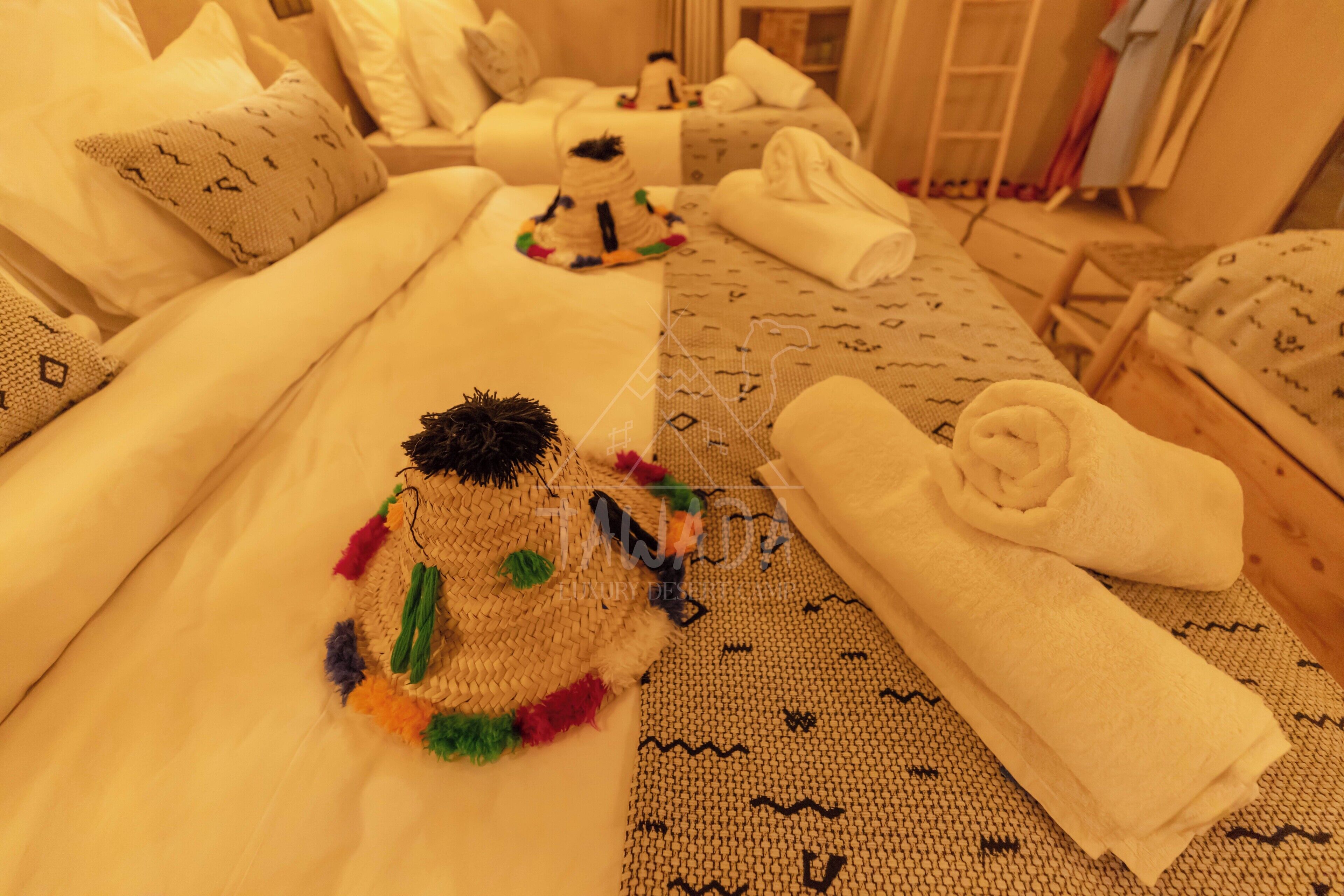 A hotel room with a bed, a small decorative item, and neatly folded towels.
