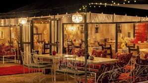 An outdoor dining area with tables and chairs, a chandelier, and a tented structure. - TAWADA LUXURY DESERT CAMP (Merzouga)
