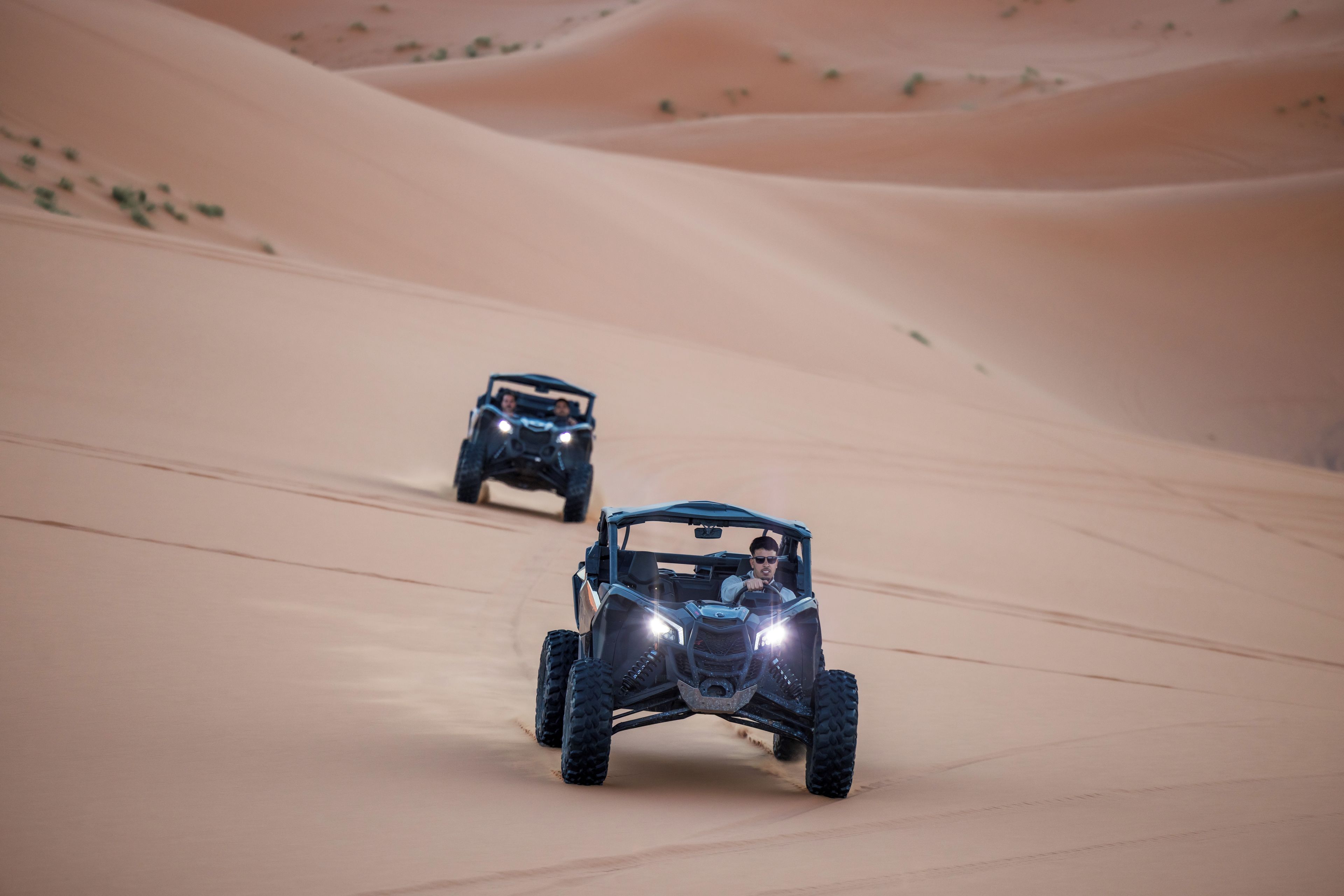 Two off-road vehicles on a sandy terrain.