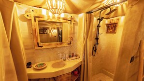 A bathroom with a wooden vanity, a mirror, a sink, a shower, and a towel rack. - TAWADA LUXURY DESERT CAMP (Merzouga)