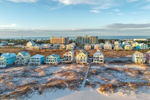Una zona costera con casas frente a la playa y un gran edificio de hotel.