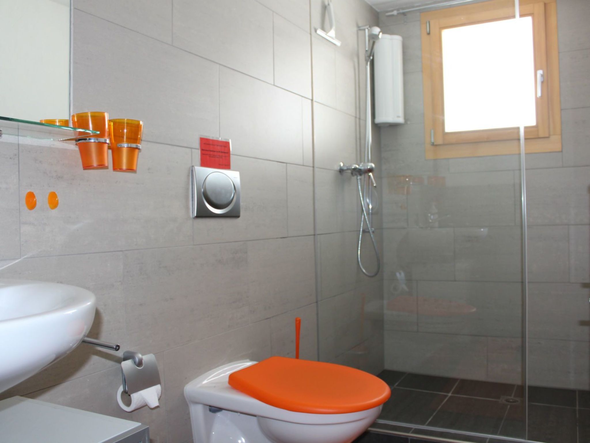 A bathroom with a toilet, sink, and shower.