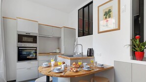 Eine kompakte Küche mit Backofen, Spüle und Essbereich, ausgestattet mit Frühstücksartikeln.