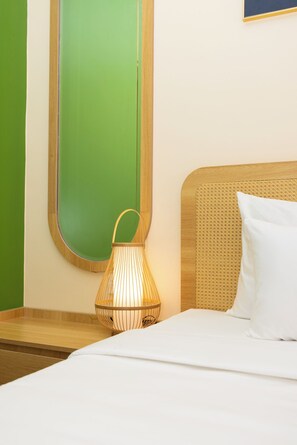 A hotel room with a bed, a nightstand, a wall-mounted mirror, and a hanging lamp. - Golden Sand Phu Quoc Hotel (Phu Quoc)