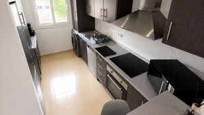 A modern kitchen with a built-in oven, a sink, and a window.