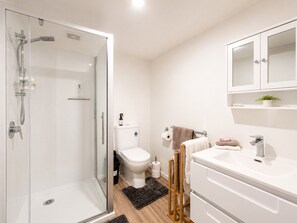A modern bathroom with a glass shower enclosure, a toilet, a sink, and a mirror cabinet. - Stylish 1BR Retreat | Patio | Walk to Shops | Parking (Whangārei)