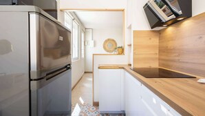 Eine moderne Küche mit einem Edelstahl-Kühlschrank, einer Holz Arbeitsplatte und einer eingebauten Mikrowelle.