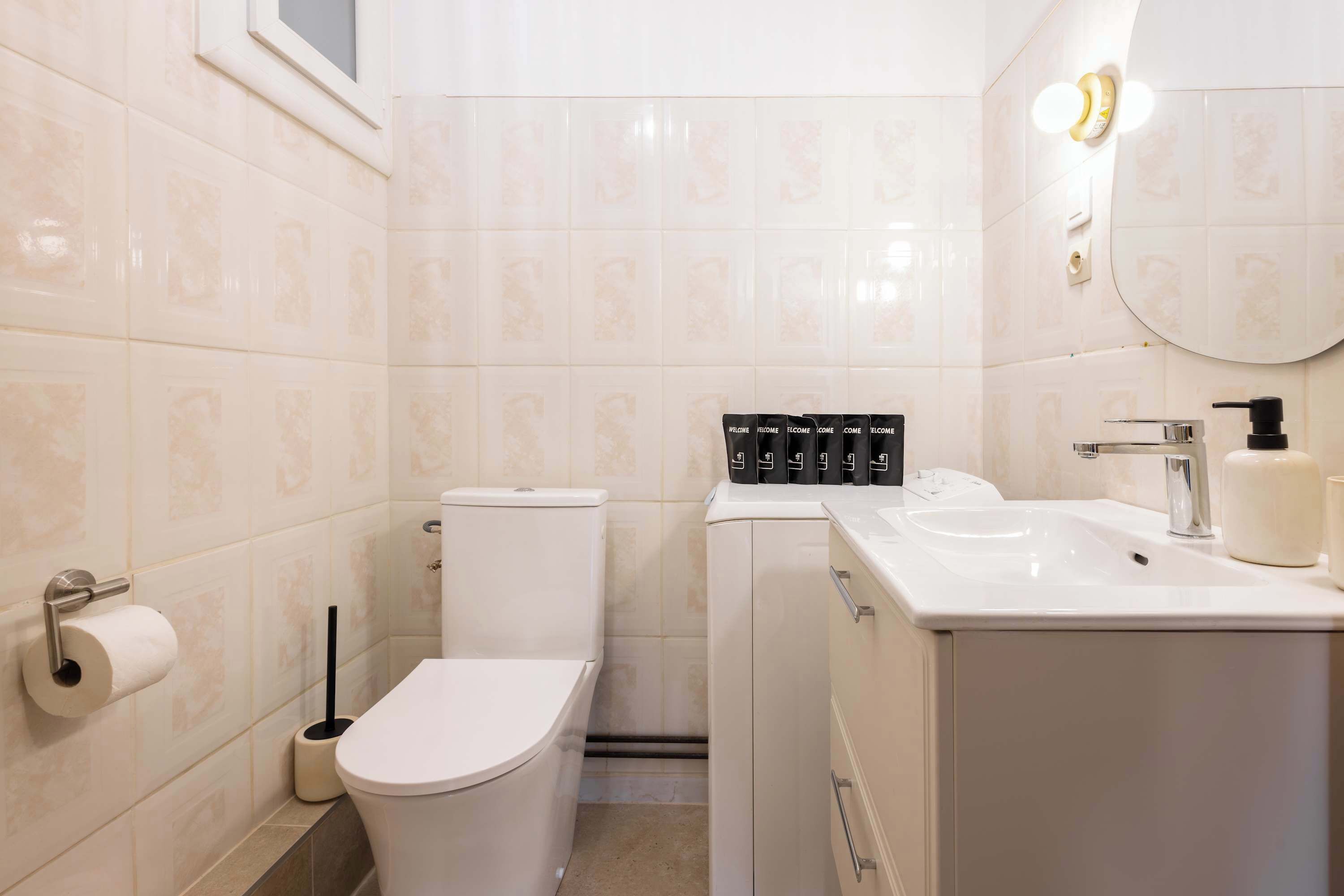 A bathroom with a toilet, sink, and a mirror.