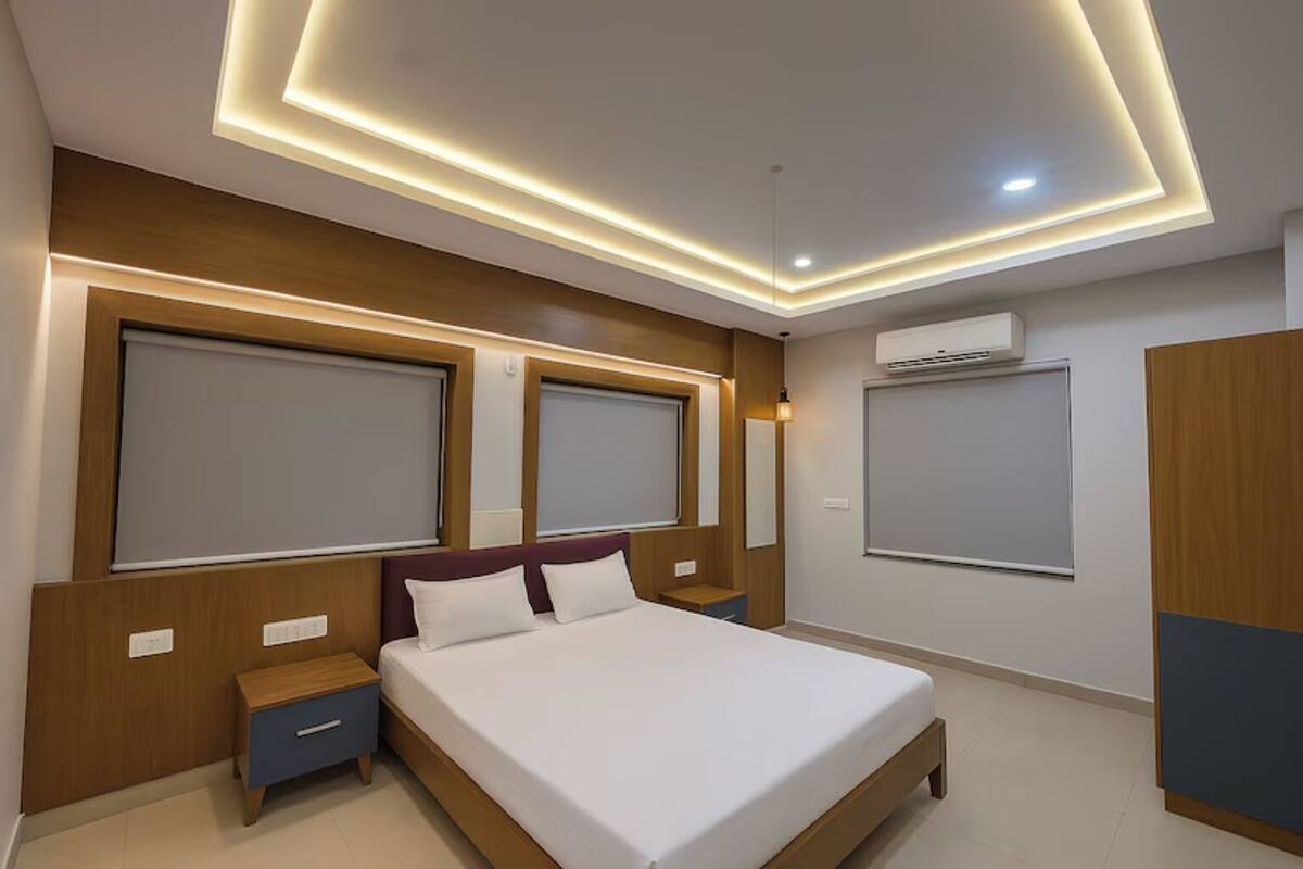 A modern bedroom with a bed, nightstands, and built-in lighting.