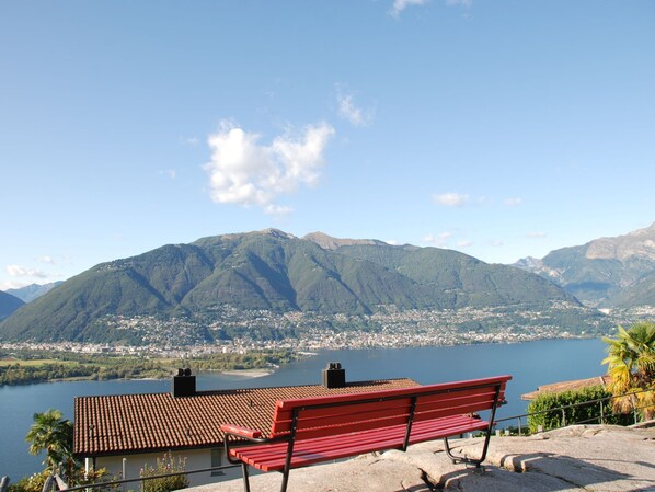 A red bench overlooking a lake with mountains in the background.