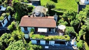 A house with a tiled roof, a covered patio, and a garden. - Casa Poggio Verde by Interhome (Magadino)