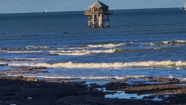 A coastal scene with a small wooden structure on stilts in the water, waves crashing onto a rocky shore. - Cosy & quiet studio with private parking, near ocean and town center. (La Rochelle 17000)