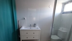 A bathroom with a white sink, mirror, and toilet. - Cosy & quiet studio with private parking, near ocean and town center. (La Rochelle 17000)