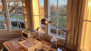 Un bureau en bois avec un casse-tête de type labyrinthe, une lampe et une boîte de mouchoirs.