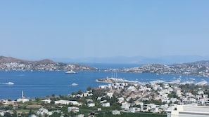 Eine Küstenstadt mit weißen Gebäuden, einem Yachthafen mit Booten und einem klaren, blauen Meer.