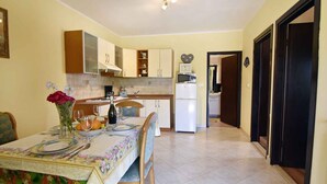 A compact kitchen with a dining area, a refrigerator, and a microwave. - Comfy accommodation in Umag (Umag)