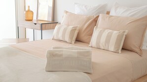 A neatly made bed with pillows and a folded towel. - Luxury Beachfront Studio - Panoramic sea view - Direct beach access - Corsica (Olmeto)