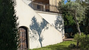 A modern building with a sloped roof, a balcony with metal railings, and a door with a wooden frame. - Gîte avec piscine privée situé à Uzès (Uzès)