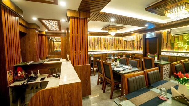 A restaurant with wooden paneling, a bar area, and a neon sign.