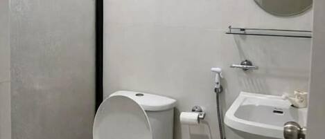 A small, modern bathroom with a toilet, bidet, and sink.