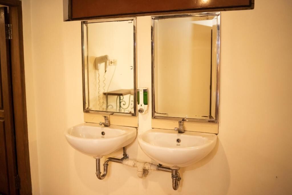 Two wall-mounted sinks with chrome fixtures and mirrors above them.
