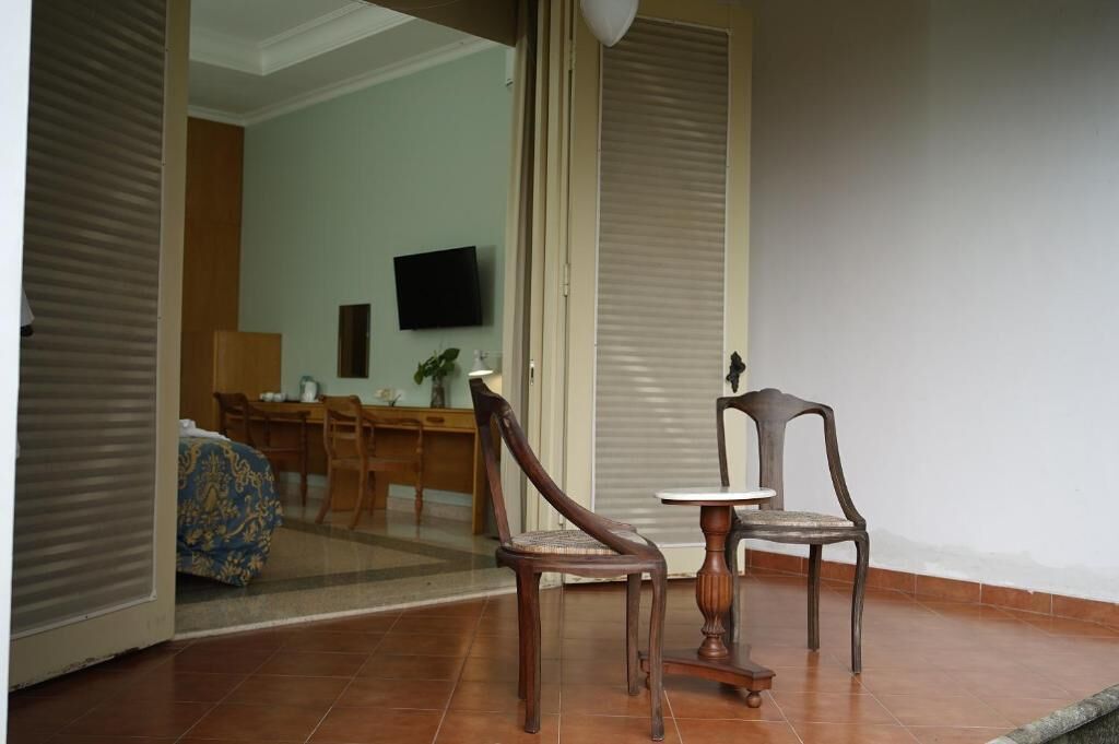 Una habitación con una mesa de comedor, sillas, televisor y puerta corrediza.