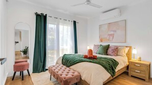 Un dormitorio con cama, mesita de noche y ventilador de techo.
