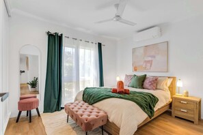 A bedroom with a bed, bedside table, nightstand, and a ceiling fan. - Mimpi Tropics Retreat, Holloways Beach (Holloways Beach)
