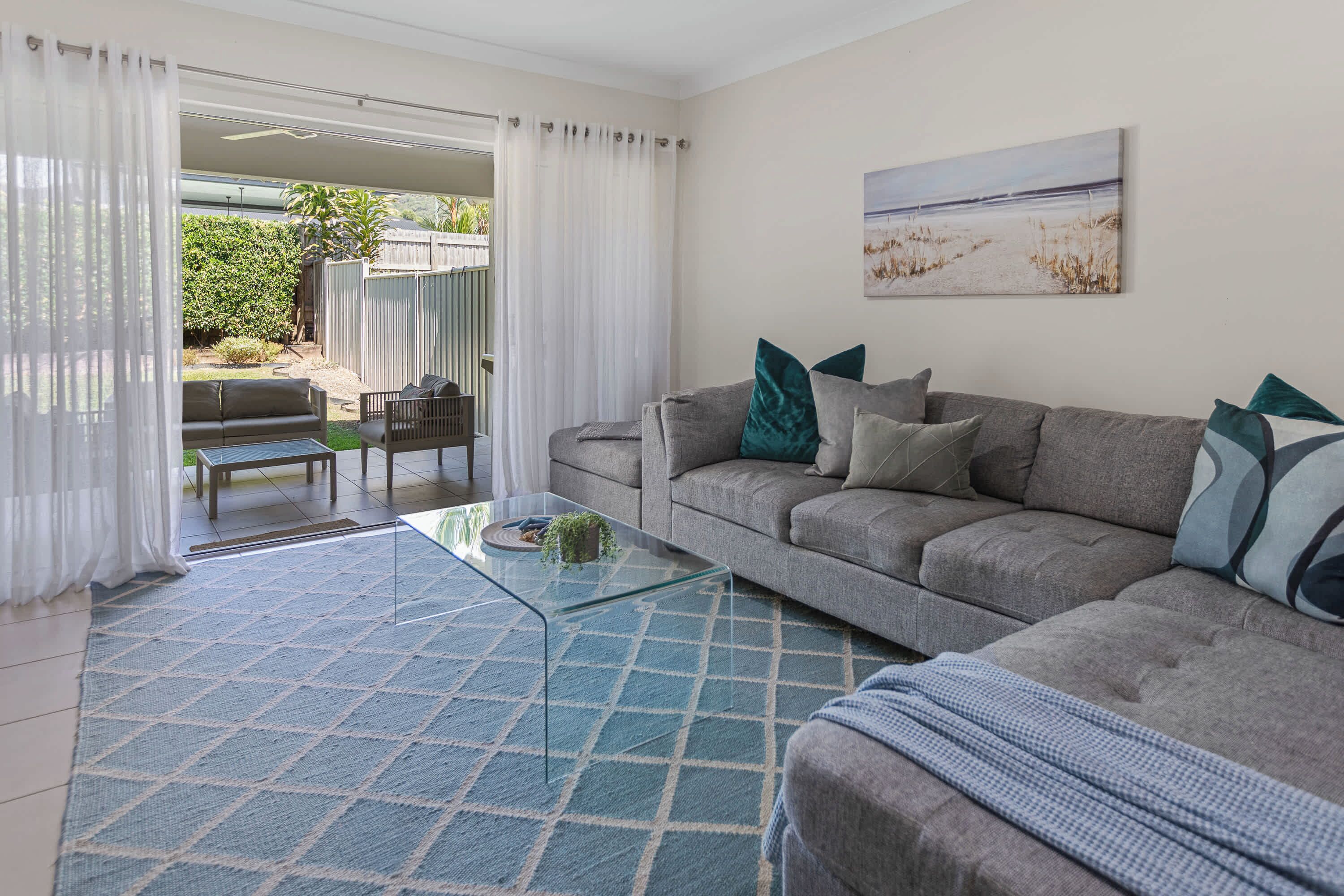 A living room with a sofa, a coffee table, and a painting on the wall.