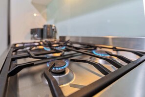 A kitchen with a gas stove and a coffee maker.