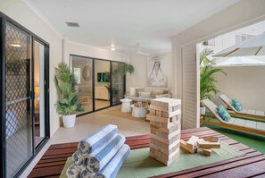 A modern indoor space with a seating area, a jigsaw puzzle, and a view through a glass door. - Spacious Retreat with Courtyard & Resort Pool (Cairns North)