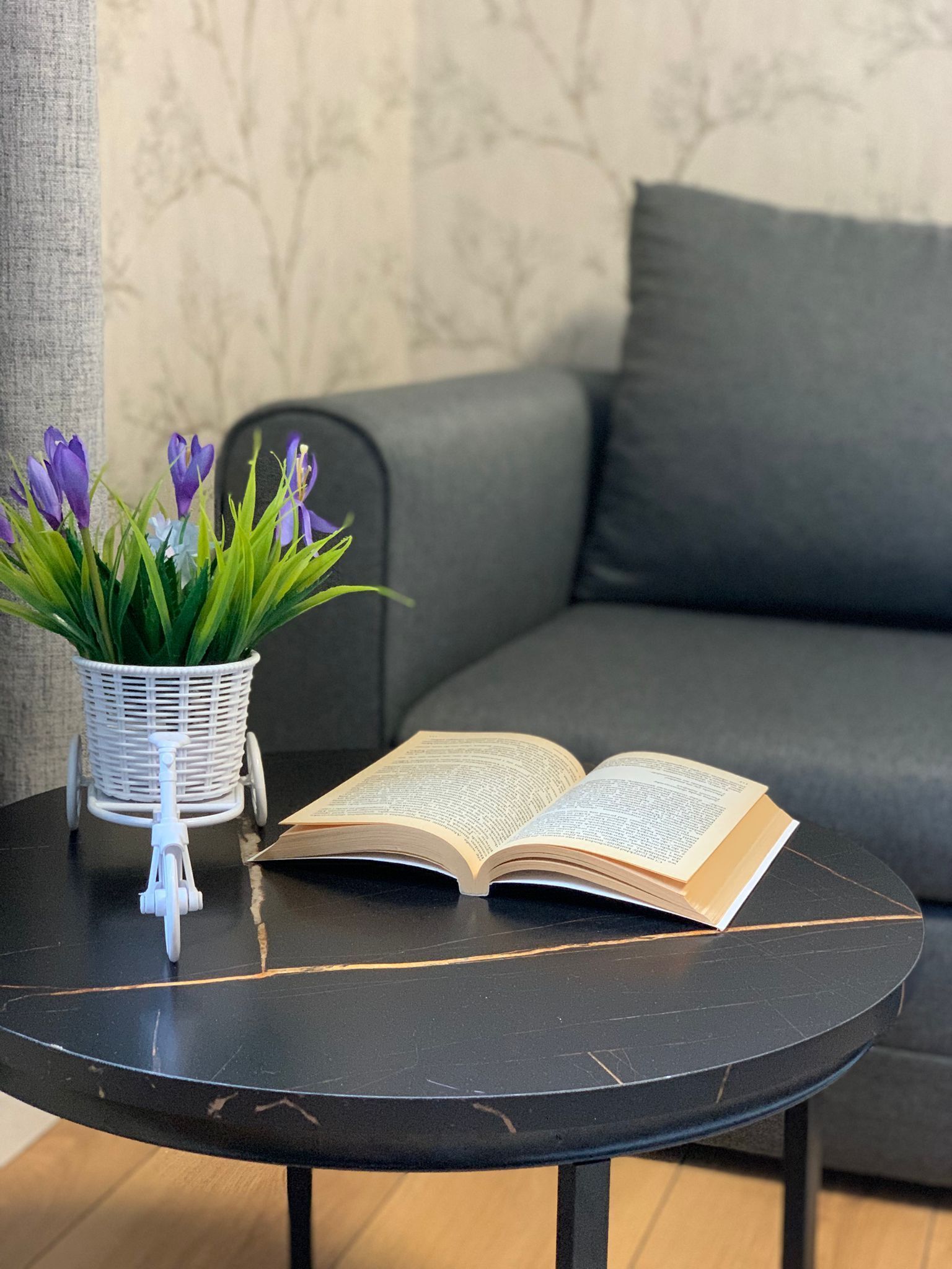A round table with a book and a small potted plant.