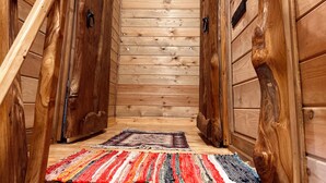 A wooden staircase with a striped rug at the bottom.