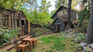 Une cabane rustique dotée d’une terrasse en bois et d’une petite table.