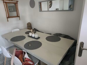 Ein Esszimmer mit einem modernen Tisch, einer kleinen Dekoreinrichtung und einem Spiegel an der Wand.
