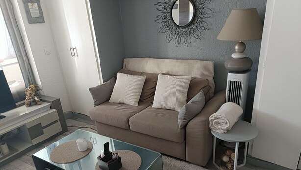 A living room with a sofa, coffee table, and ottoman. - T2 cabin with terrace, close to beach and port, all amenities on foot (Saint-Cyprien)
