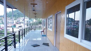 Un balcón techado con vistas a una zona residencial en la ladera de una colina.