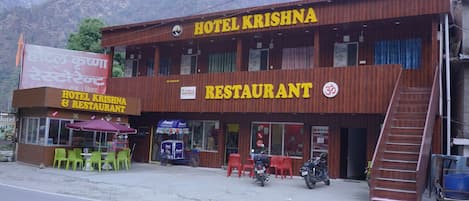A two-story building with a sign reading 'Hotel Krishna Restaurant.'