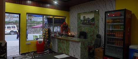 A restaurant with a counter, seating area, and a Coca-Cola refrigerator.