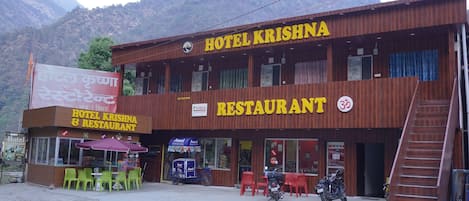 A two-story building with a sign reading 'Hotel Krishna Restaurant.'