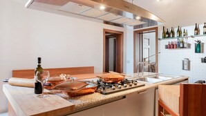 Een moderne keuken met een centraal eiland, roestvrijstalen apparatuur en een wijnrek.