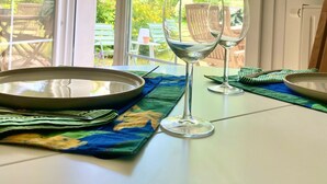 Ein Esstisch mit einem Glas Wasser, einer Schüssel und einer Platzunterlage.