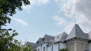 Eine Steinsäule mit einem Schild, auf dem 'LE CLOS SAINT GUENOLÉ' steht, und einem Straßenschild für 'CHEMIN DE KERVASTARD'.